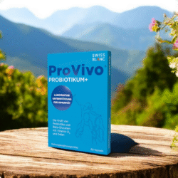 Škatlica prehranskega dopolnila ProVivo Probiotikum+ znamke Swiss Blanc, postavljena na leseni podlagi v naravnem gorskem okolju.